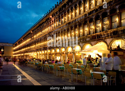 Un cafe orchestra suona al di fuori del costoso caffè sulla Piazza San Marco, Venezia, per attrarre custom di sera Foto Stock