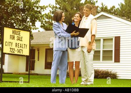 Broker che mostra coppia giovane una casa Foto Stock