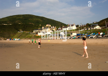 Giovane uomo donna riproduzione di Frisbee sulla spiaggia di Tresaith Cardigan Bay Ceredigion West Wales Foto Stock