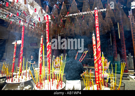 Uomo con grandi flaming bastoncini di incenso prega al Tempio Thien Hau Ho Chi Minh City Vietnam Foto Stock