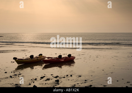 Canoe sulla spiaggia villaggio Llangrannog Cardigan Bay Ceredigion west wales serata estiva bassa marea Foto Stock