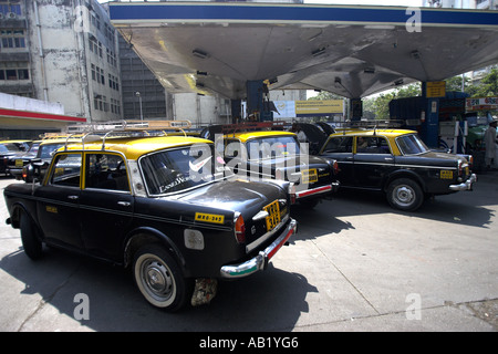 Nero e giallo taxi Mumbai line up per il gas combustibile al garage India Foto Stock