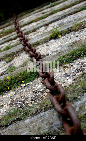 Catena arrugginita che riposa sulle traversine ferroviarie alla banchina di Buckler's Hard, Hampshire Foto Stock