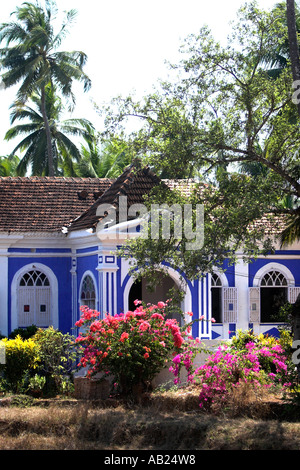 Attraente blu e bianco su un unico piano country house Casa Robello con ante e fiori tropicali Anjuna Goa in India Foto Stock