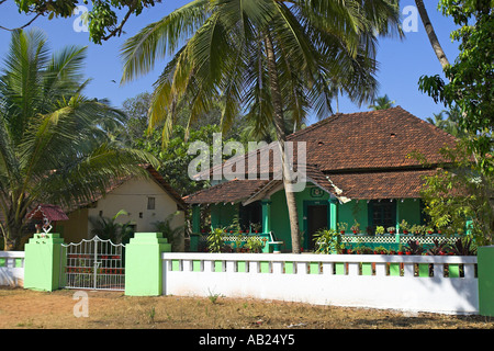 Attraente verde su un unico piano casa piastrellato con palme e vasi di piante tropicali Goa in India Foto Stock