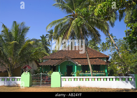 Attraente verde su un unico piano casa piastrellato con palme e vasi di piante tropicali Goa in India Foto Stock