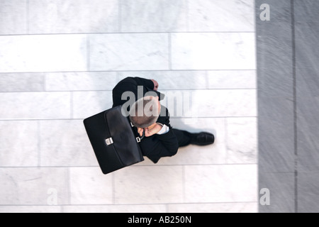 Manager in una tuta camminare con valigetta da sopra Manager im Anzug mit Aktentasche Foto Stock