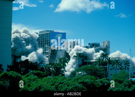 Demolizione controllata di Kaiser Hospital Hawaii edificio collaspes in mezzo alle palme ondeggianti e polvere Foto Stock