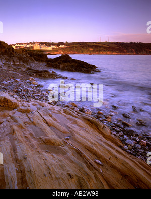 Mountbatten Bay Plymouth Devon al tramonto con vista Staddon altezze e le onde e le rocce sulla spiaggia Foto Stock