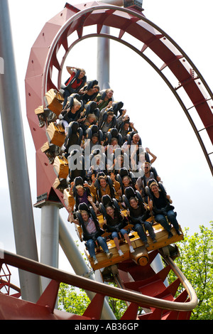 La gente a cavallo di un roller coaster presso il parco divertimenti Giardini di Tivoli a Copenhagen, in Danimarca. Foto Stock