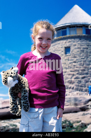 Dai Capelli rossi ragazza in vacanza con pet tiger bambola al Ministro dell isola New Brunswick Canada con il castello come edificio Foto Stock