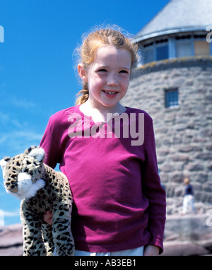 Dai Capelli rossi ragazza in vacanza sorridente con pet doll tiger a Ministro dell isola New Brunswick Canada Foto Stock