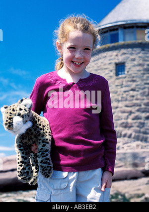 Dai Capelli rossi ragazza in vacanza sorridente con pet doll tiger a Ministro dell isola New Brunswick Canada Foto Stock