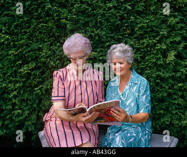 Senior ladies lettura all'aperto Foto Stock