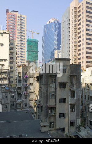 La giustapposizione di vecchi caseggiati e nuovi grattacieli in costruzione nel distretto Centrale dell'Isola di Hong Kong. Foto Stock