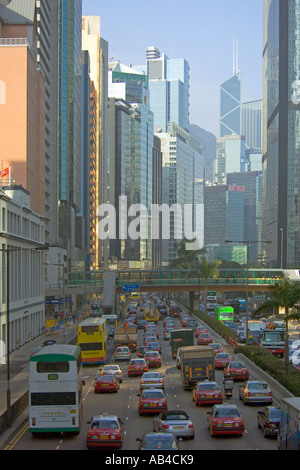 Una vista dei grattacieli e il traffico con molti tradizionali taxi rosso lungo Gloucester Road sull isola di Hong Kong. Foto Stock