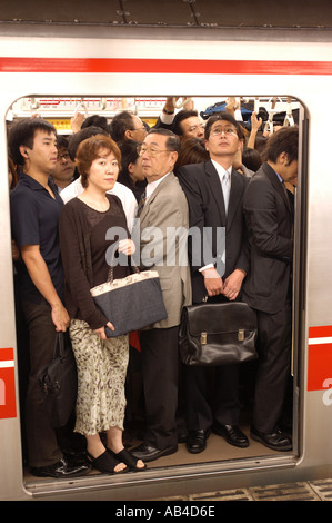 Pendolari su un affollato treno della metropolitana presso la Stazione di Shinjuku Tokyo Foto Stock