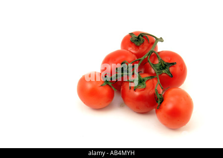 Primo piano di un gruppo di sei bagnato pomodori rossi su sfondo bianco. Foto Stock