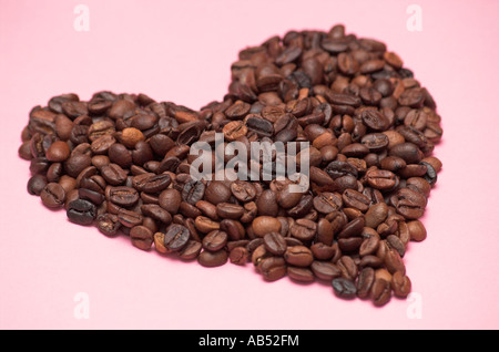 I chicchi di caffè in una pila sagomata come un cuore close up Foto Stock