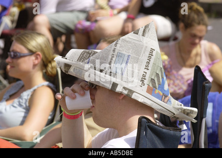 Udienza nel sole caldo, indossando un cappello di giornale, ascoltando la banda a l annuale Brecon Jazz Festival Powys Mid Wales UK Foto Stock