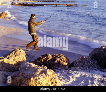 Pescatore surfcasting di prima mattina sulla spiaggia della Florida Foto Stock