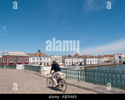 Ciclista sulla Ponta Romana o ponte romano con fondamenta romane spanning Rio fiume Gilao in Tavira Algarve Portogallo Europa Foto Stock