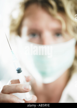 Un lavoratore di salute circa per somministrare il farmaco al paziente tramite iniezione Foto Stock