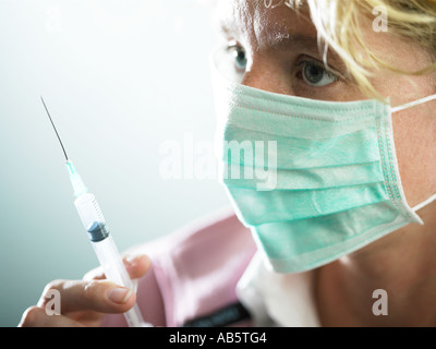 Un lavoratore di salute circa per somministrare il farmaco al paziente tramite iniezione Foto Stock