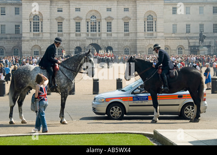 Horseguards Parade polizia montata sul dovere durante la modifica della cerimonia di guardia guardato dalla zona pedonale con la bandiera europea sulla camicia Foto Stock