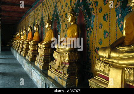 Una fila di immagini dorate del buddha nel chiostro del Grand Palace Bangkok Thailandia. Foto Stock