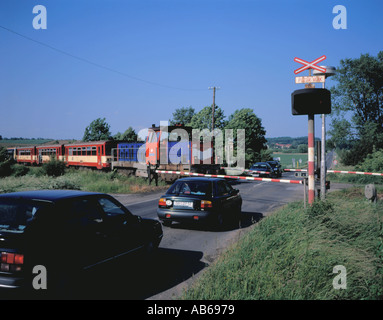 Piccolo treno passeggeri attraversando un livello rurale attraversando, nel nord della Repubblica ceca. Foto Stock