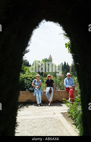 Medio di età compresa tra i turisti nel rilassante giardino vestito in estate casual abiti e cappelli di paglia. Gli europei Foto Stock