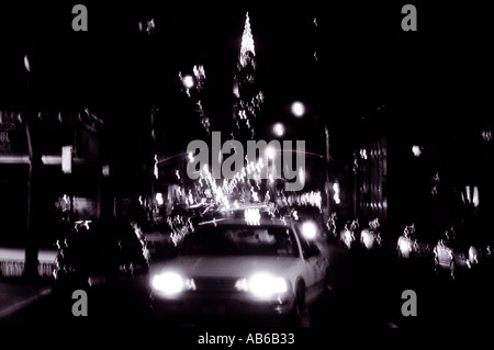 Taxi di notte con luci sfocate e Chrysler Building di New York City STATI UNITI D'AMERICA Foto Stock