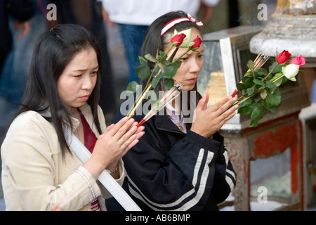 Buddisti di inginocchiarsi e pregare la posa di fiori e candele incenso Wat Phra That Doi Suthep Thailandia Foto Stock