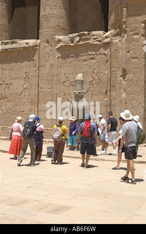 Turisti ammirare la statua in granito del falcon intitolata dio Horus in Egitto, il Tempio di Edfu Egitto.Il tempio è dedicato a Horus Foto Stock