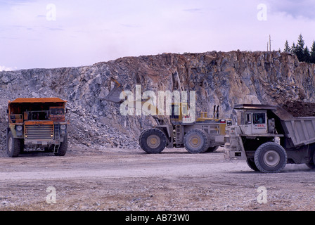 Caricatore a estremità anteriore il caricamento di 100 Ton Mining autocarri con cassone ribaltabile in corrispondenza di aprire fossa Cava di calcare sulla miniera Texada Isola della Columbia britannica in Canada Foto Stock