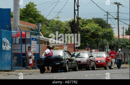 Taxicabs parcheggio di fronte del terminal degli autobus in un quartiere povero di Managua capitale del Nicaragua, America Centrale Foto Stock