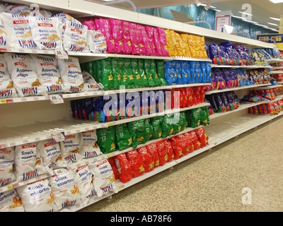 Vista interna Tesco supermercato cibo e negozio di alimentari corsia per lo shopping display colorato assortito grandi pacchetti di patatine in sacchetti impilati Sugli scaffali UK Foto Stock