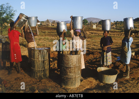 Giovani donne porting secchi di acqua nelle zone rurali dello Zimbabwe village Foto Stock