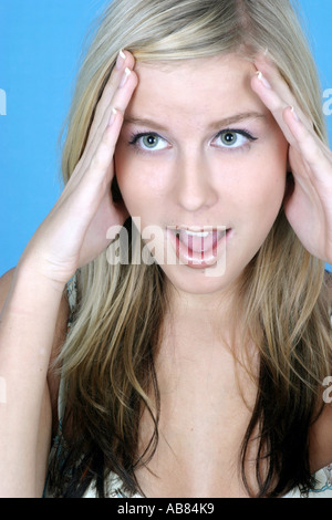 Bionda donna longhaired, toccando i suoi templi. Foto Stock