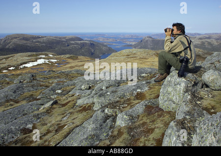 La fauna selvatica watcher affacciato sulla tundra in alto al di sopra del fiordo norvegese, Norvegia Foto Stock