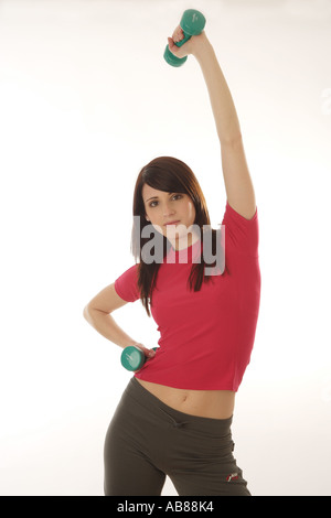 Ritratto di una giovane donna darkhaired in t-shirt rossa, formazione con dumb campane Foto Stock