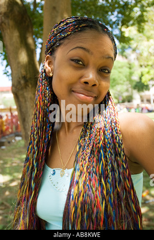 West Indies Trinidad Carnival Porto di Spagna Ritratto di giovane donna con colorati intrecciati capelli lunghi in posa per la fotocamera Foto Stock