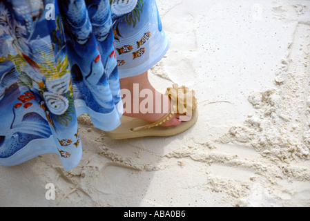 Camminando lungo la spiaggia in sarong e flip flop Baros island resort Maldive Foto Stock