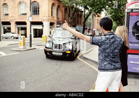 Giovane salutando taxi Foto Stock