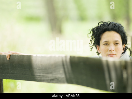 Donna che mantiene sulla recinzione di legno Foto Stock