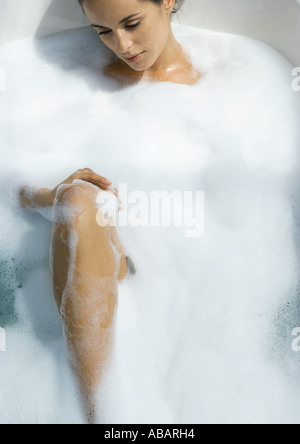 Donna prendendo bubble bath Foto Stock