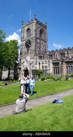 Persone rilassarsi sul prato di fronte la chiesa della Santa Trinità Skipton North Yorkshire Foto Stock