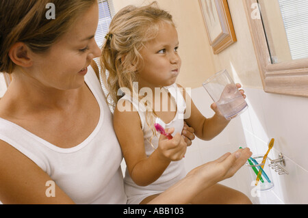 Madre aiutare mia figlia spazzola denti Foto Stock