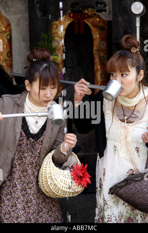 Belle Donne bere da una molla nella Kiyomizudera complesso tempio a Kyoto in Giappone Foto Stock